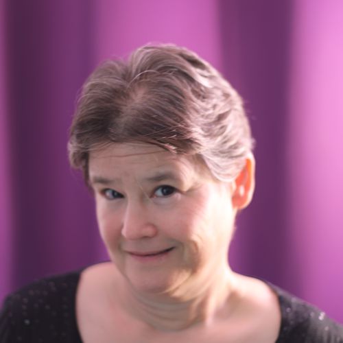 A photograph of the author, a middle aged white woman with brown hair and eyes, smiling out at the viewer.